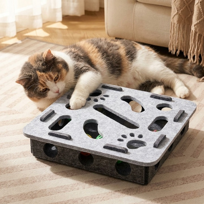 chat couché jouant tranquillement avec son jouet pour chat